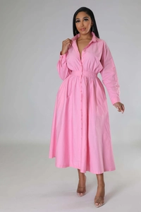 Détail d'une robe chemise rose à manches longues avec col à revers et taille plissée