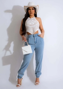 Dettaglio del top all'uncinetto bianco stile bohémien con ricamo floreale e jeans
