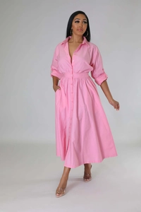 Détail d'une robe chemise rose avec un col à revers et une fermeture à boutons sur le devant