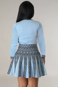 Rear view of light blue knitted set with long sleeve top and pleated skirt featuring greek key patterns
