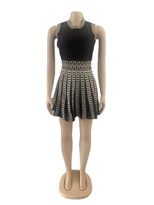 Detail of the Greek Key pattern on a black sleeveless knitted dress with pleated skirt