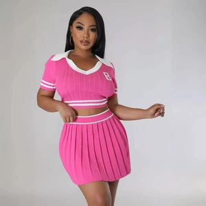 Pink knit two-piece set with V-neck polo top and pleated mini skirt featuring white stripes