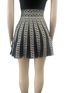 Close-up of high-waist pleated dress featuring Greek Meander patterns and knit texture
