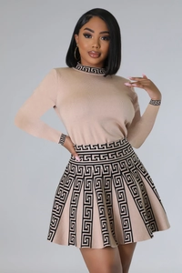 Detail of knitted pleated dress with black Greek key pattern on neckline and waist