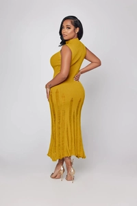 Dettaglio dell'abito in maglia giallo zenzero smanicato con orlo strappato dal design moderno