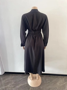 Détail de la taille élastiquée et du tissu plissé sur une robe midi à manches longues