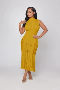 Dettaglio dell'abito in maglia giallo senape con trama a fori verticali usurati