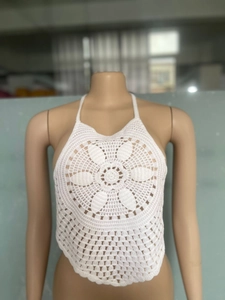 Dettaglio top bianco all'uncinetto con motivo floreale e scollo all'americana boho