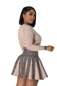 Detail of beige knitted two-piece set with black meander pattern and pleated mini skirt