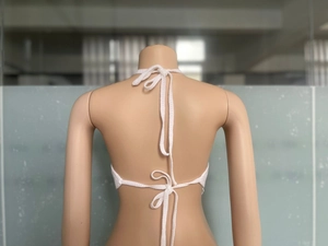 Dettaglio posteriore del top bianco lavorato all'uncinetto con lacci regolabili sul collo