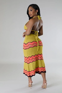 Detail of yellow knit crochet two-piece set featuring backless halter top and chevron skirt