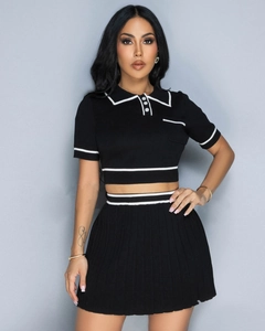 Close-up of knit two-piece set featuring contrast white trim and polo neck details