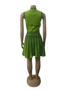 Rear view of green knit two-piece set featuring black Greek key patterns on skirt and top