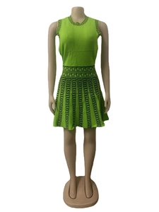 Detail showing the Greek Key pattern on the waist and hem of a green knit dress