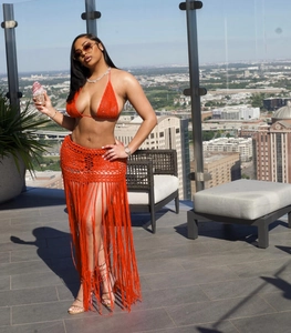 Detail of orange crochet beach set featuring long tassels and a halter neck design