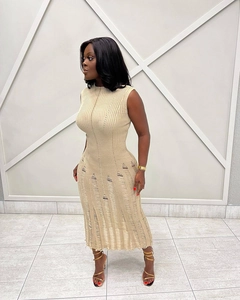 Dettaglio dell'abito in maglia beige senza maniche con orlo strappato e trama a coste