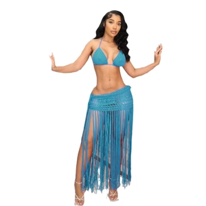 Detail of teal crochet bikini top and long fringe knit beach skirt set on white background