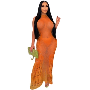 Détail de la texture en maille crochet orange sur une robe de plage longue à licou