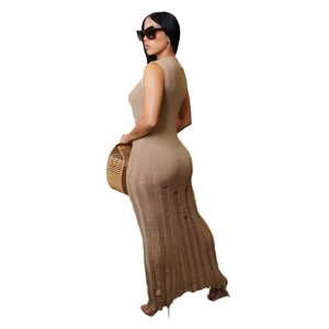 Dettaglio della trama a maglia e delle frange sull'orlo di questo abito lungo beige