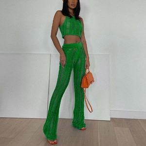 Detail of green knit two-piece set featuring distressed texture and cutout design