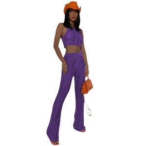 Detail of purple ribbed knit crop top and flared pants with distressed hollow-out texture