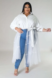 Detail of plus size white blouse featuring puff sleeves and layered tulle mesh hemline