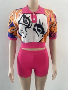 Detail of knit crop polo top with pearl buttons and abstract face pattern with pink shorts