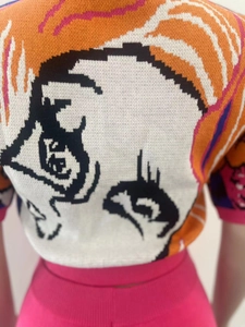 Detail of colorful jacquard knit top featuring anime eye graphic on the back