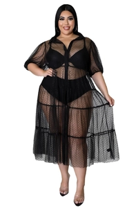 Detail eines schwarzen Plus-Size-Netzkleids mit Polka-Dots, Rüschen und transparentem Stoff