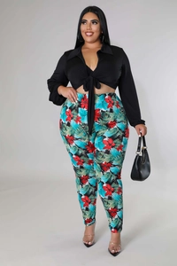 Detail of plus-size two-piece set featuring a black tie-front crop top and floral print pants