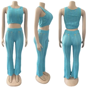 Detailed view of bright blue knitted crop top and flared pants with distressed cut-out texture
