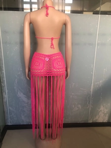 Detail of pink crochet bikini set featuring intricate hollow knits and long fringe design