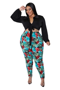 Detail of plus size two-piece set featuring tropical floral pants and black tie-up shirt