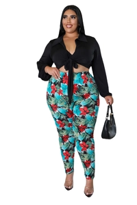 Detail of plus size two-piece set featuring a black tie-up top and floral print leggings