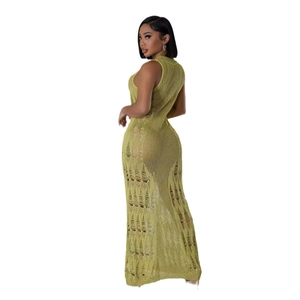 Détail d'une robe longue en maille émeraude avec des textures ajourées et des déchirures