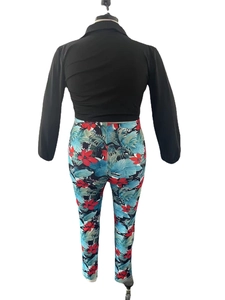 Close-up of women's two-piece set with black long sleeve top and tropical floral pants