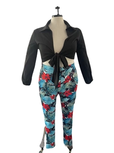 Detail of tropical print trousers and black tie-front crop shirt two-piece outfit