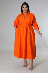 Detail of a bright orange long-sleeve shirt dress with buttons and waist pleats