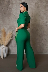 Detail view of dark green short-sleeved jumpsuit with gold buttons and turn-down collar