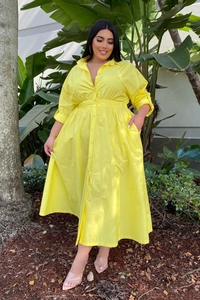 Outdoor full-body shot of a bright yellow plus size long sleeve shirt dress with high waist