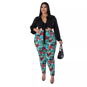Plus size two-piece set featuring black V-neck tie-up top and tropical floral print pants