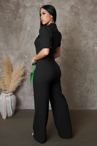Detail of black short sleeve jumpsuit with contouring seams and wide leg fit