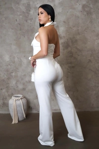 Detail des weißen Neckholder-Jumpsuits mit rückenfreiem Design und weitem Beinverlauf