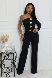 Détail d'une combinaison noire à une épaule avec grands boutons dorés et jambe large