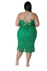 Detail of plus size green crochet dress featuring cross-back ties and fringe hemline