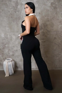 Detail eines schwarzen Neckholder-Jumpsuits mit weißem Kontrastkragen und rückenfreiem Design