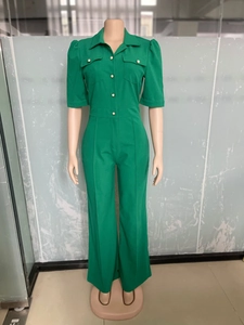 Detail of emerald green short sleeve jumpsuit featuring notch lapels and pearl buttons
