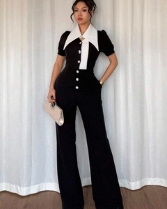 Detail of contrast lapel and button closure on high waist sleeveless jumpsuit