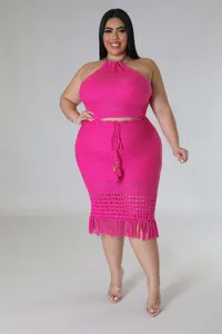 Macro detail of rose red crochet knit two-piece set featuring tassels and fringe textures