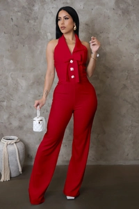 Detail eines roten Neckholder-Jumpsuits mit Schleife und weitem Bein in hoher Taille